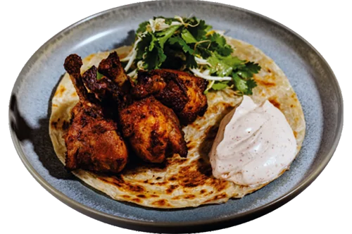 Tandoori chicken legs on a roti flatbread